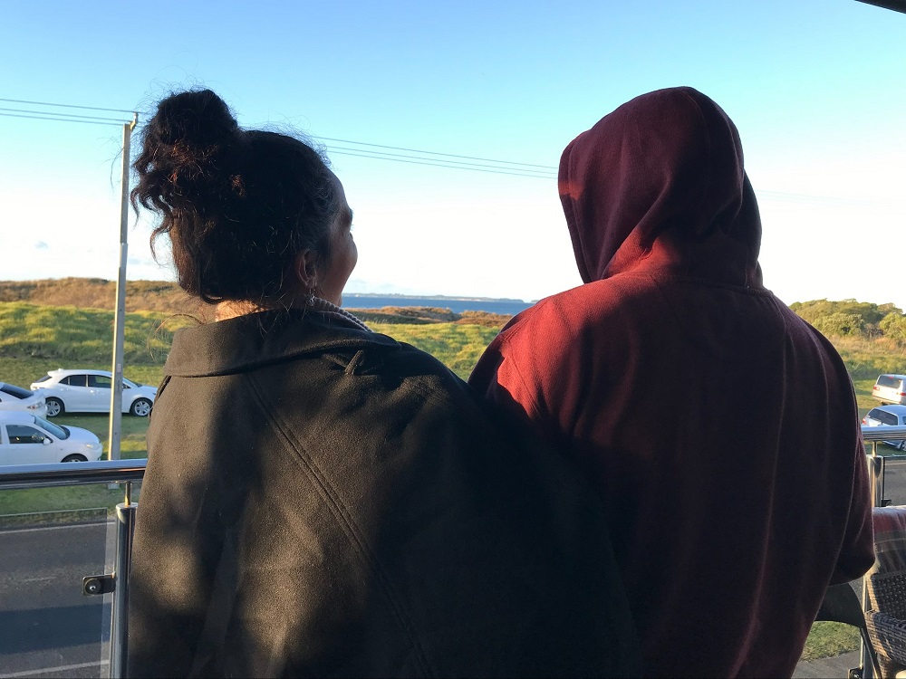 Two people looking out to the land and ocean