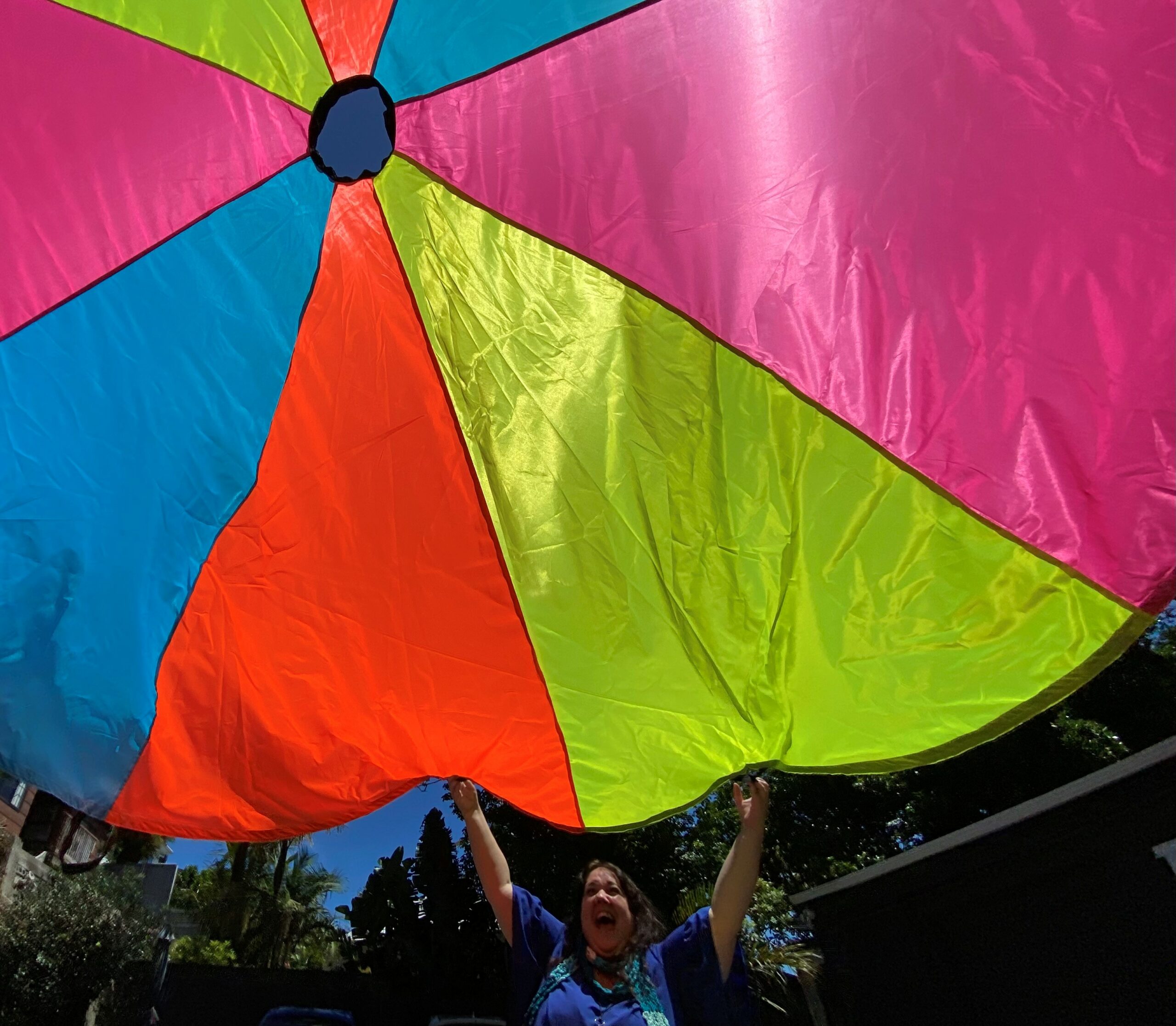 A Real staff member throws up a colourful parachute - one of the sensory tools they use.